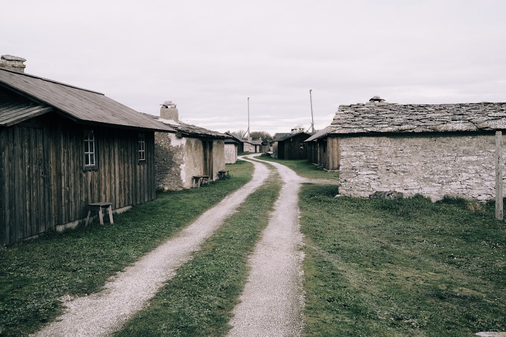 a dirt road between two old buildings