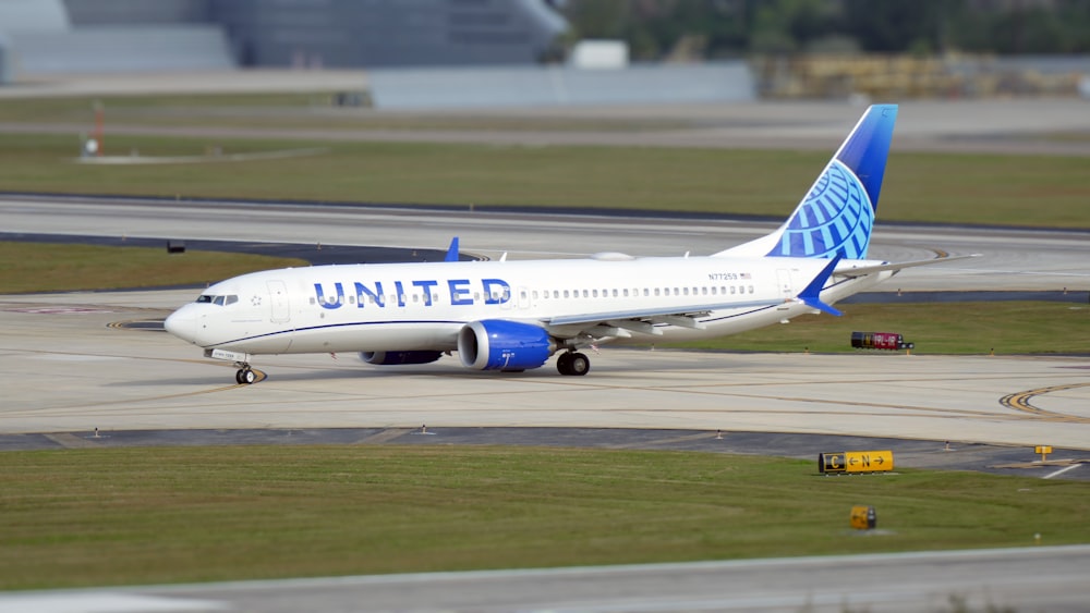 a white and blue airplane is on a runway