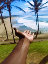 Close-up of hands exchanging house keys with a Florida beach view in the background.