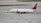 A commercial airplane is being towed by a small tow vehicle on an airport tarmac. The aircraft, with Delta Airlines branding, is positioned on a large paved surface with visible taxiway markings. The airplane and tow vehicle create a sense of movement and readiness.