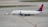 A commercial airplane is being towed by a small tow vehicle on an airport tarmac. The aircraft, with Delta Airlines branding, is positioned on a large paved surface with visible taxiway markings. The airplane and tow vehicle create a sense of movement and readiness.