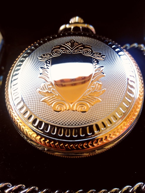 Elegant vintage gold pocket watch resting on a dark velvet cloth highlighting its craftsmanship