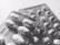 Blister packs containing tablets and pills, arranged overlapping on a flat surface. The image is in black and white, highlighting texture and form.