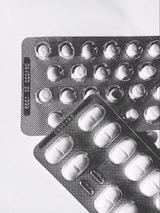 A flat lay of scattered GLP-1 patch packages with UK currency notes nearby.