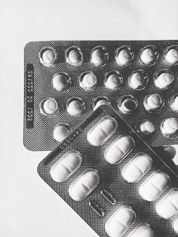 A flat lay of scattered GLP-1 patch packages with UK currency notes nearby.