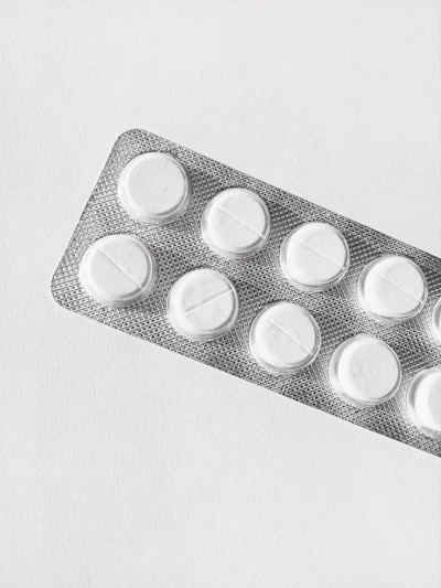 Close-up of a sleek white tablet blister pack with the Elite Pharma logo subtly embossed on each pill.