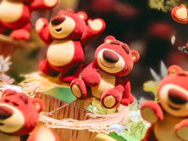 Colorful arrangement of plush teddy bears and dolls with a soft natural light highlighting their premium textures.