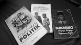 Three books are arranged on a surface, featuring political themes. The titles suggest topics related to political communication, a friendship between Sukarno and John F. Kennedy, and a biography of Sukarno.