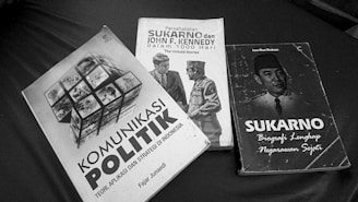 Three books are arranged on a surface, featuring political themes. The titles suggest topics related to political communication, a friendship between Sukarno and John F. Kennedy, and a biography of Sukarno.