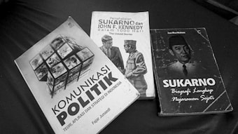 Three books are arranged on a surface, featuring political themes. The titles suggest topics related to political communication, a friendship between Sukarno and John F. Kennedy, and a biography of Sukarno.