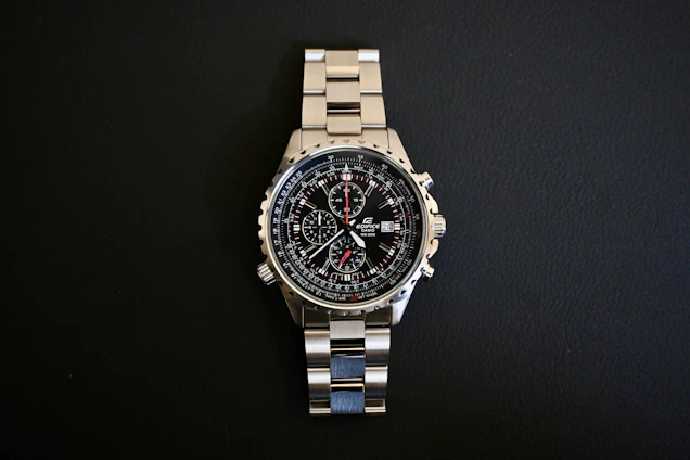 a watch sitting on top of a metal bracelet