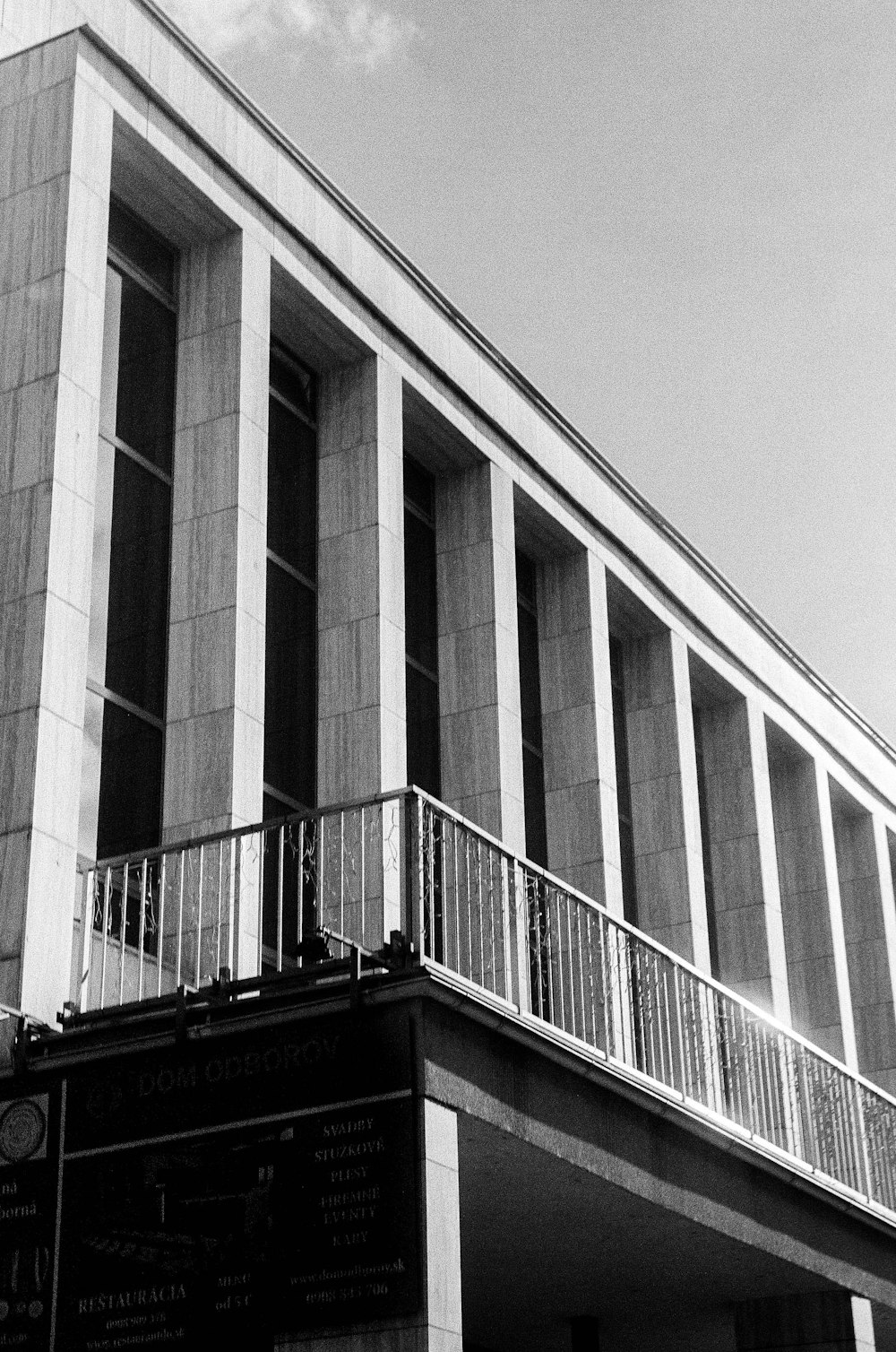 a black and white photo of a building with a balcony