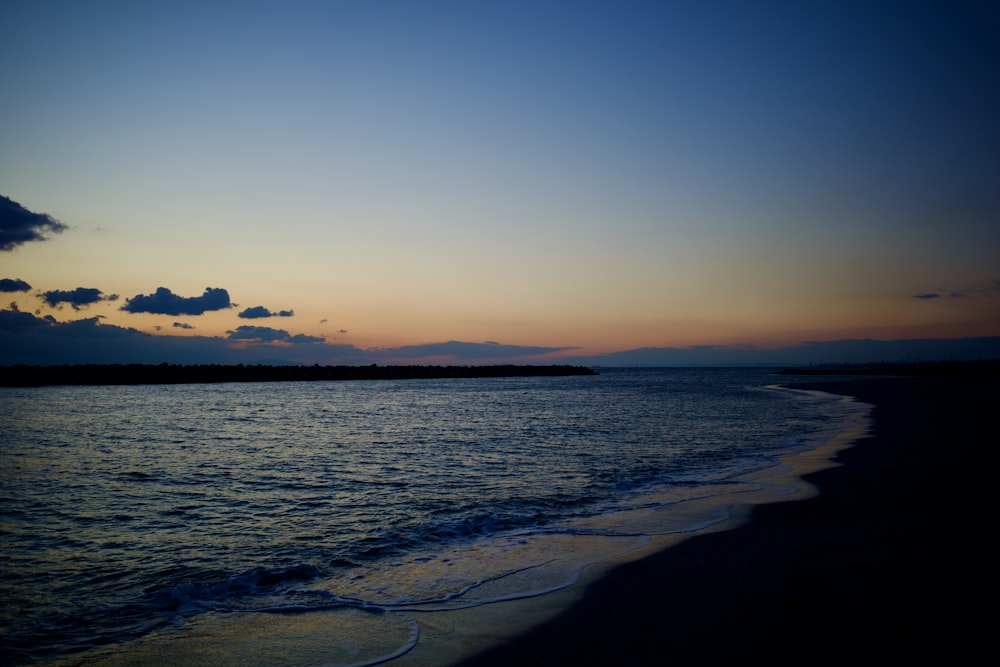 Le soleil se couche sur l’eau de la plage