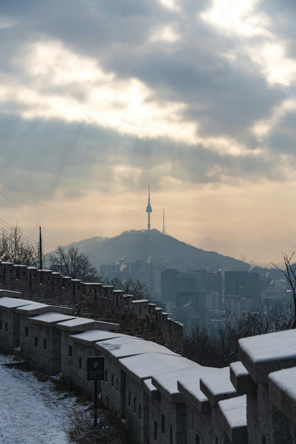 a view of a city in the distance with snow on the ground