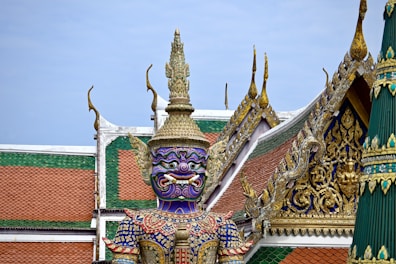 a statue of a person with a purple mask on top of a building
