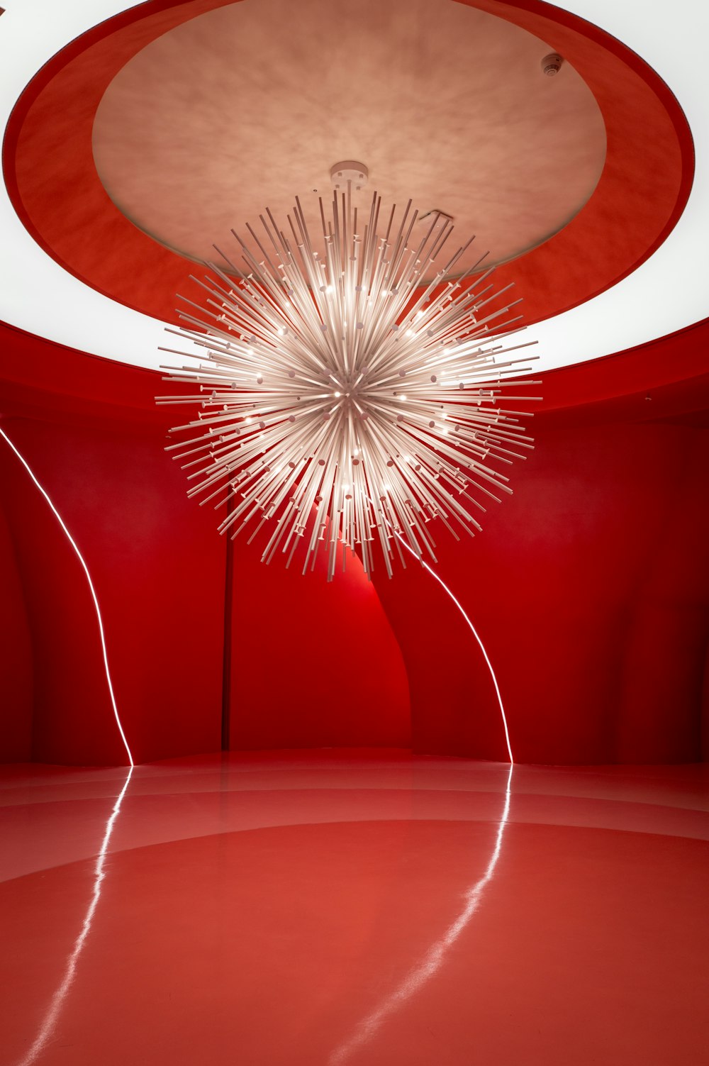 a red room with a chandelier hanging from the ceiling