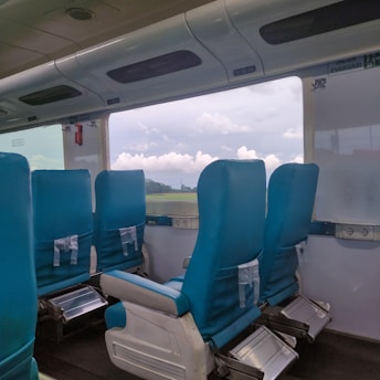Interior view of the bullet train showing plush seats and large windows with scenic views.
