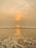 A serene beach view at sunset, highlighting golden sands and gentle waves.