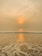 A serene beach view at sunset, highlighting golden sands and gentle waves.