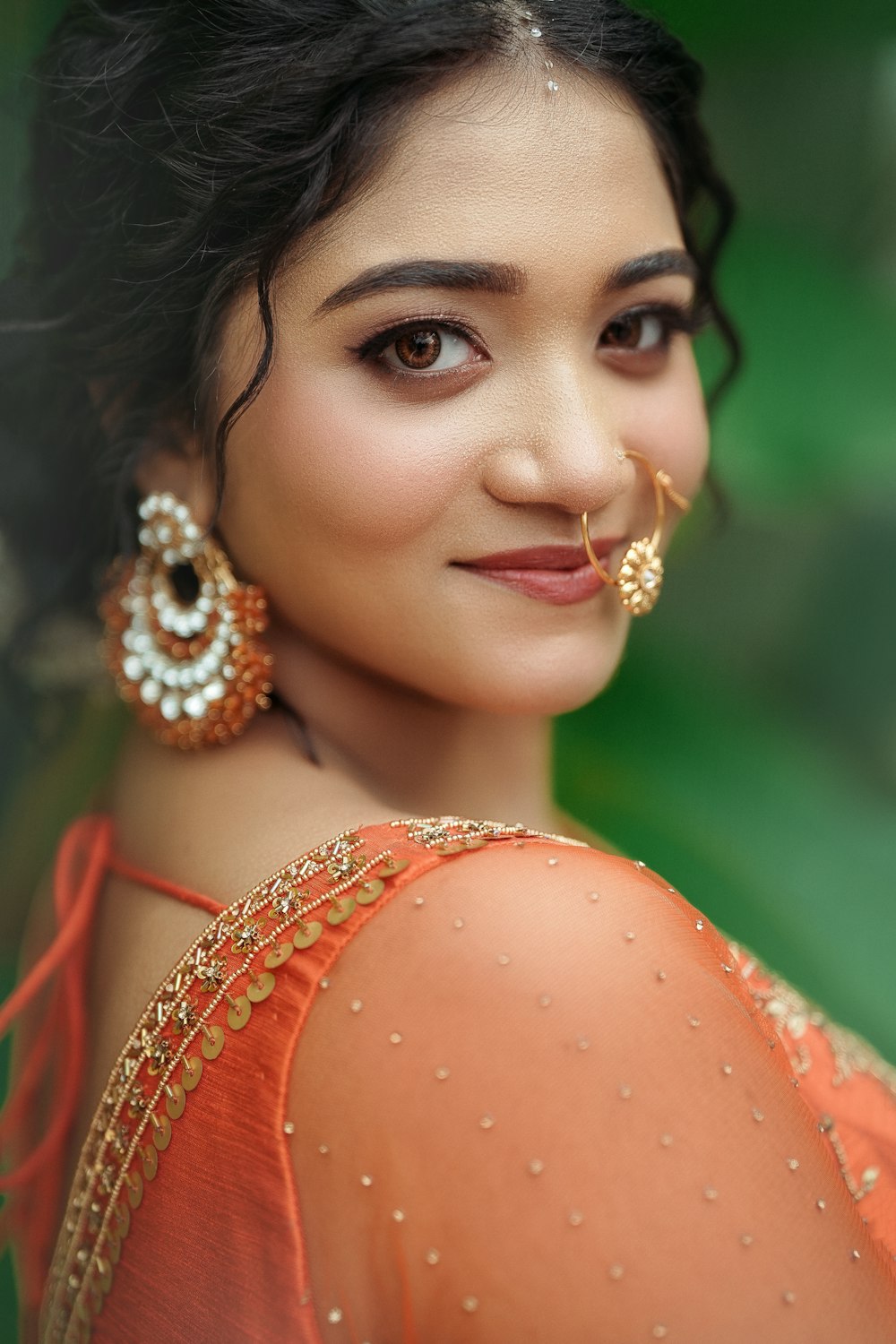 a woman with a nose ring and earrings