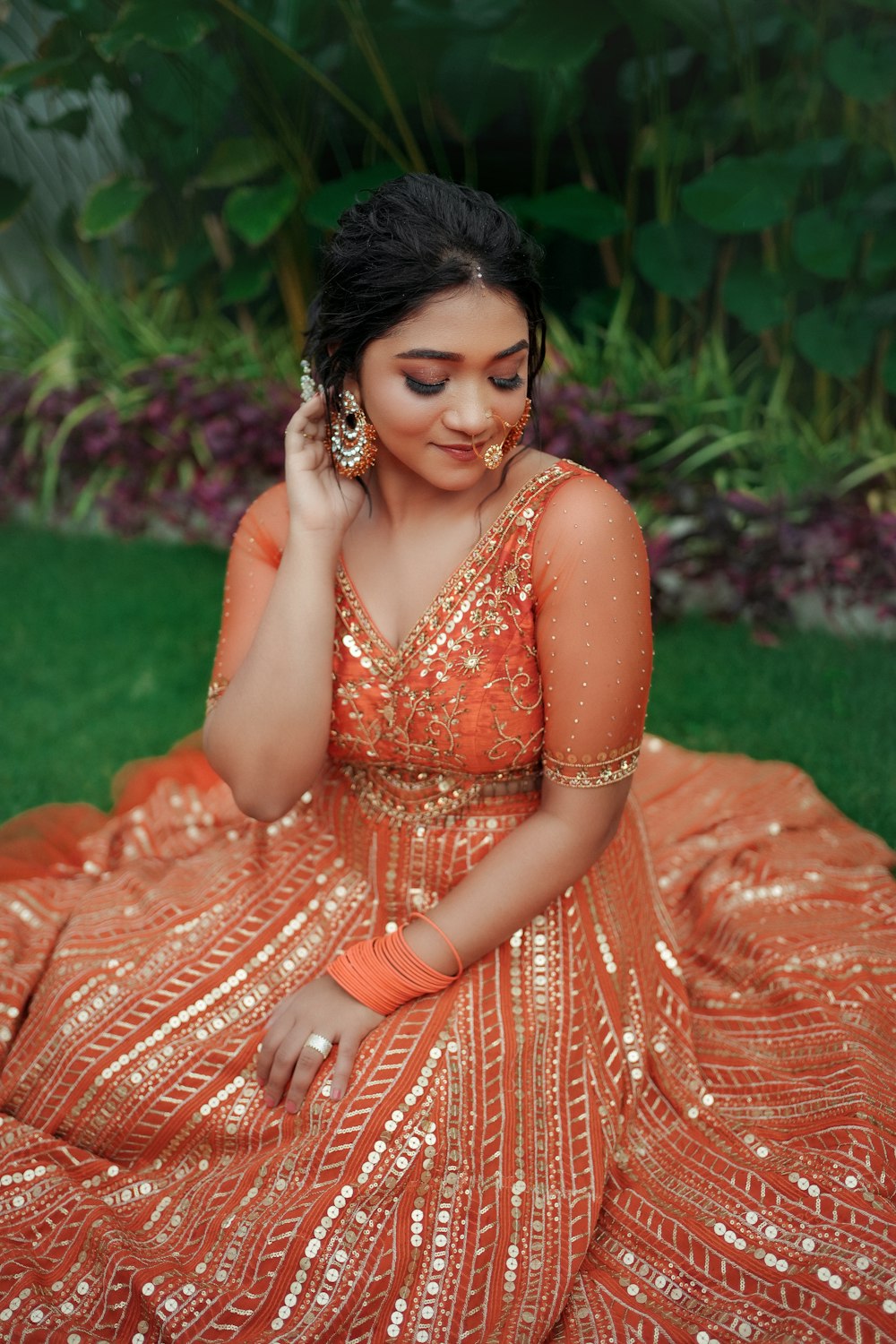 a woman in an orange dress sitting on the ground