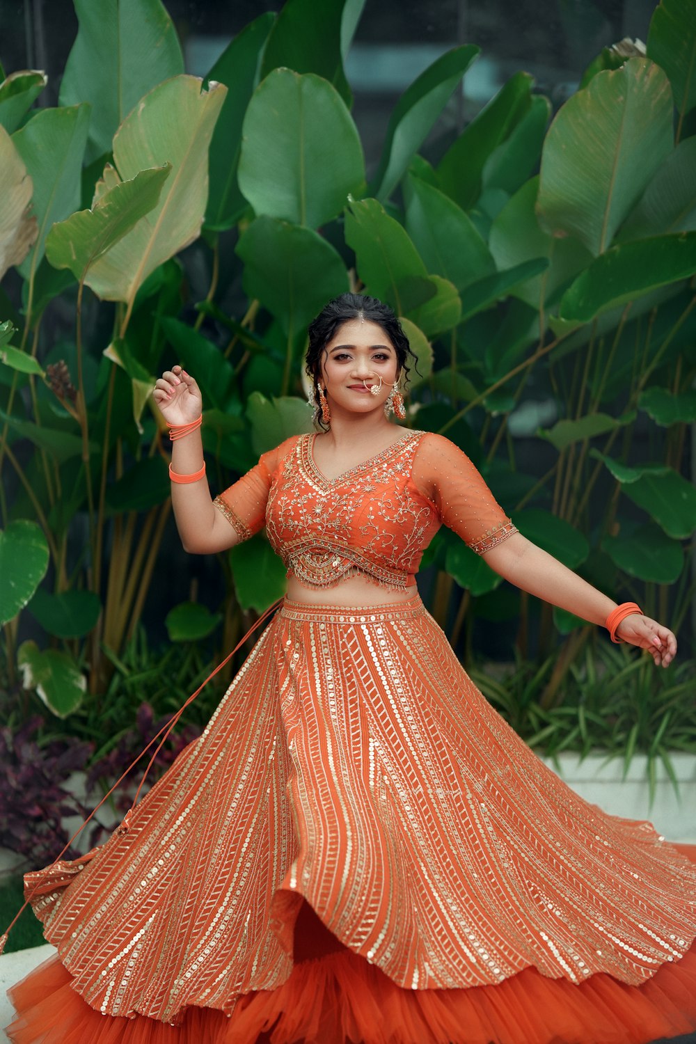 a woman in an orange and orange lehenga