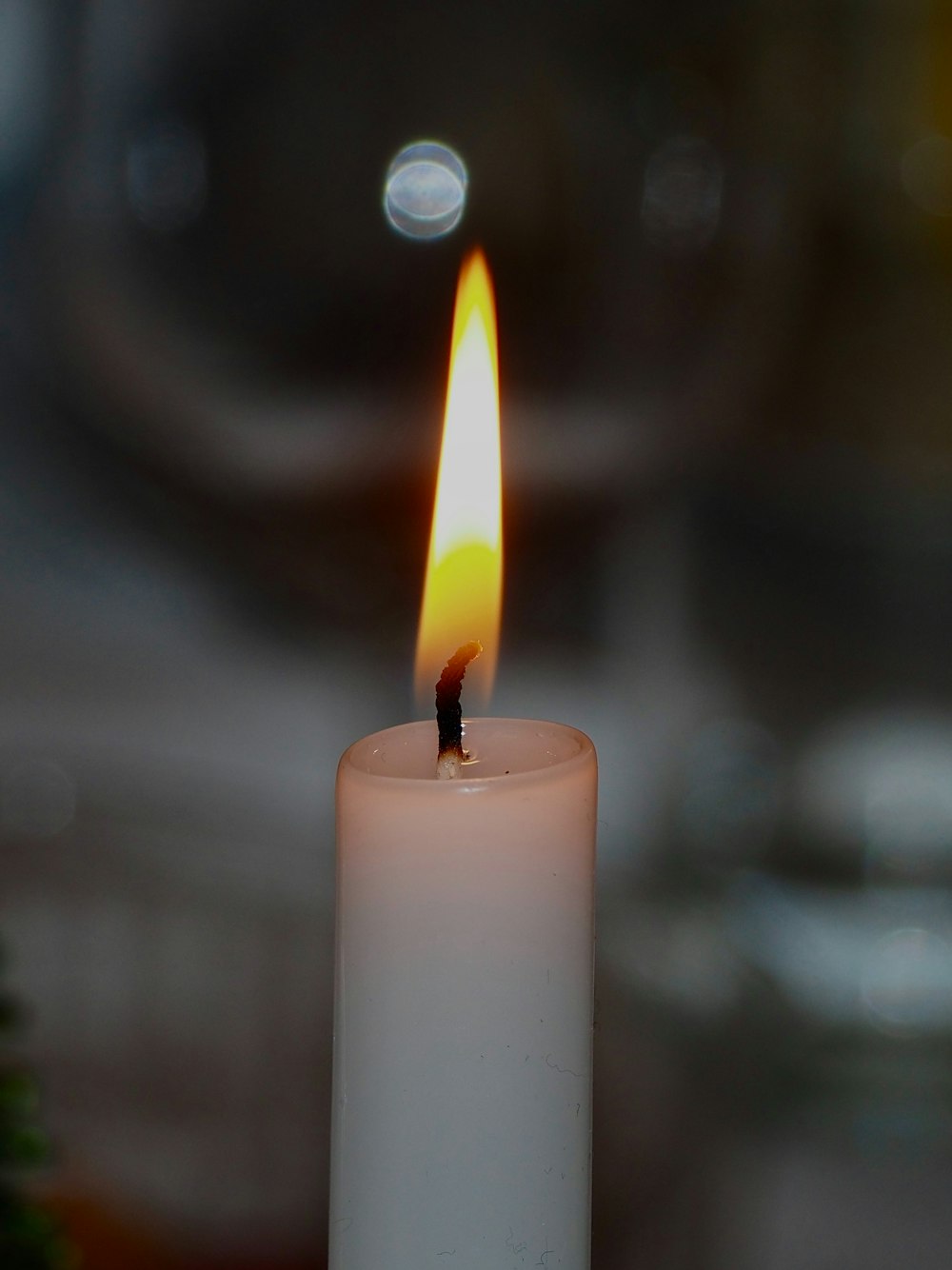 a lit candle with a blurry background