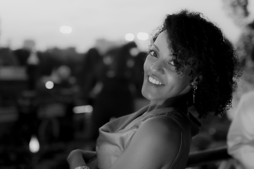 a black and white photo of a woman smiling