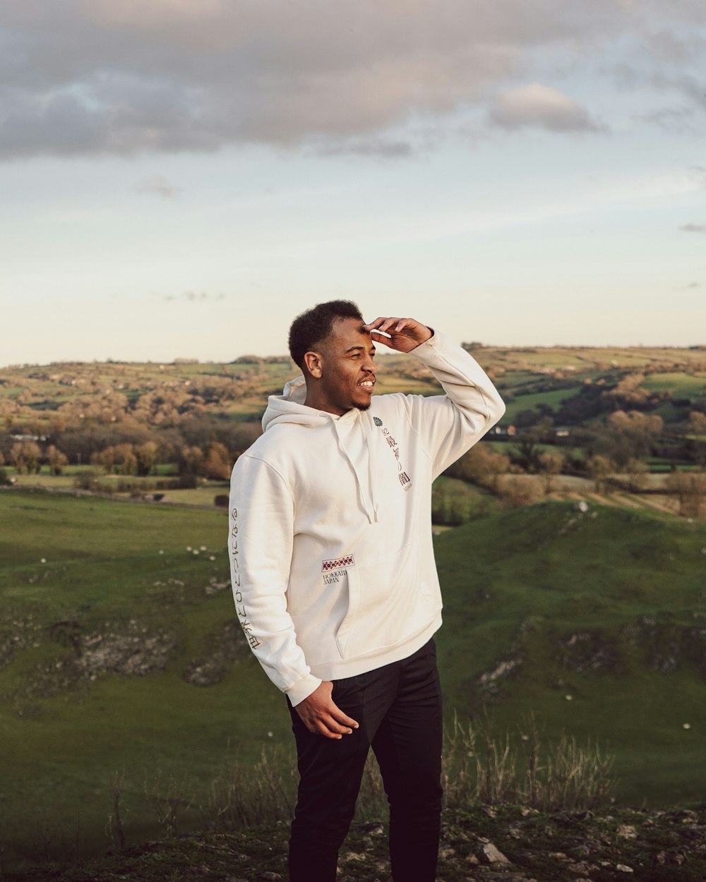 a man standing on top of a lush green hillside