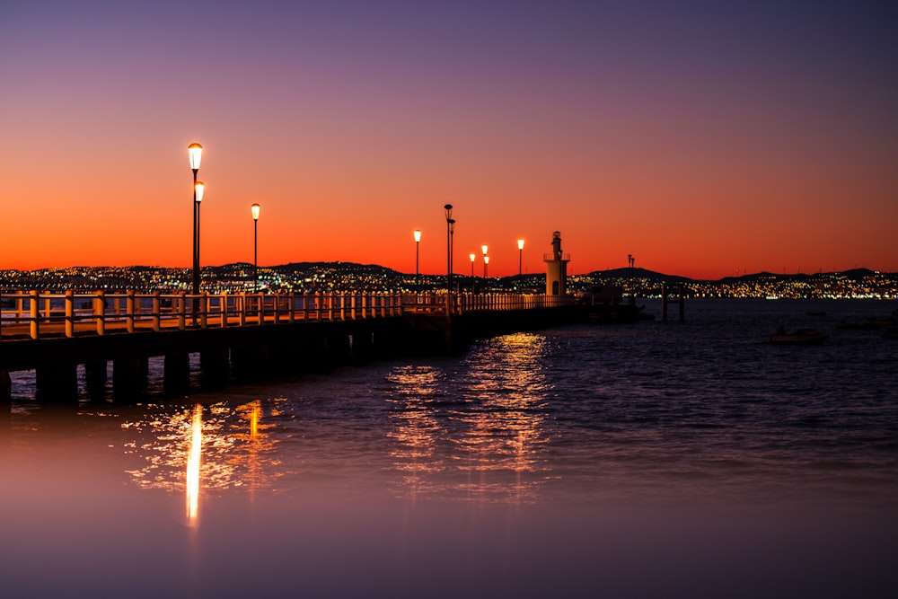 a pier with lights reflecting in the water