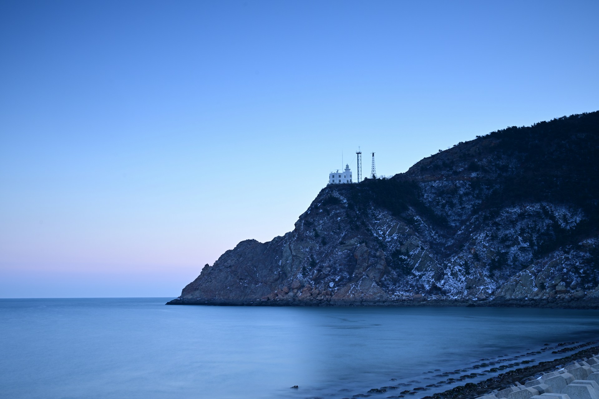 A serene view of a remote coastal area with limited connectivity, showcasing the challenges of communication in maritime zones.