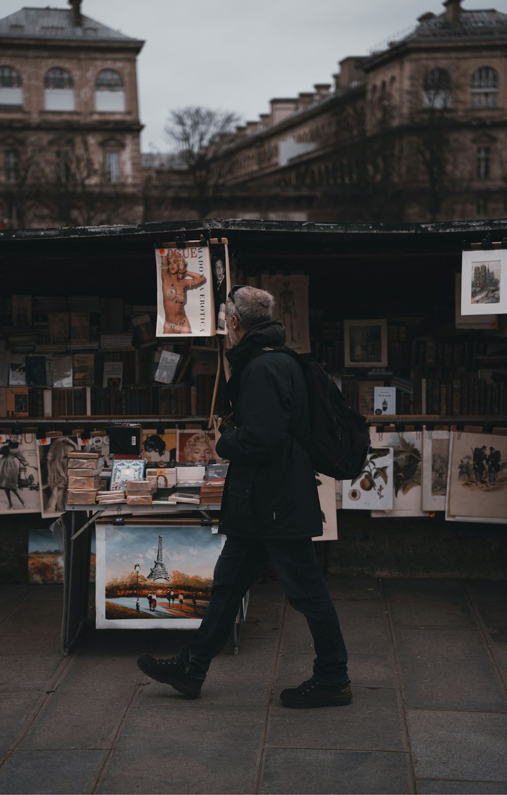 a man is walking past a book stand