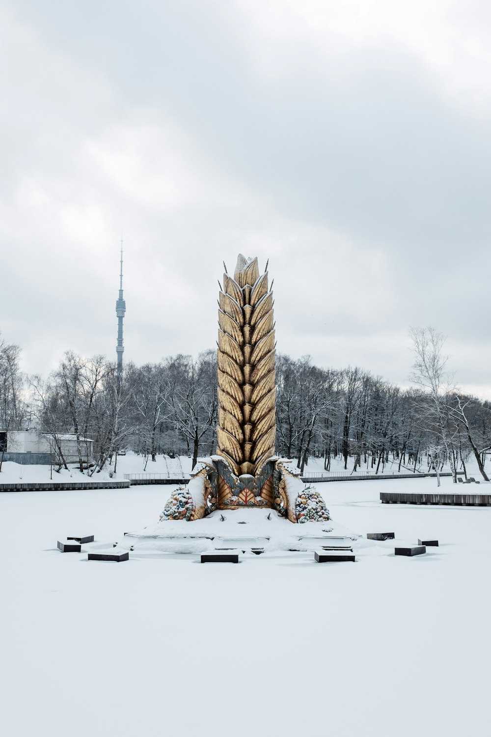 a large statue in the middle of a snowy field