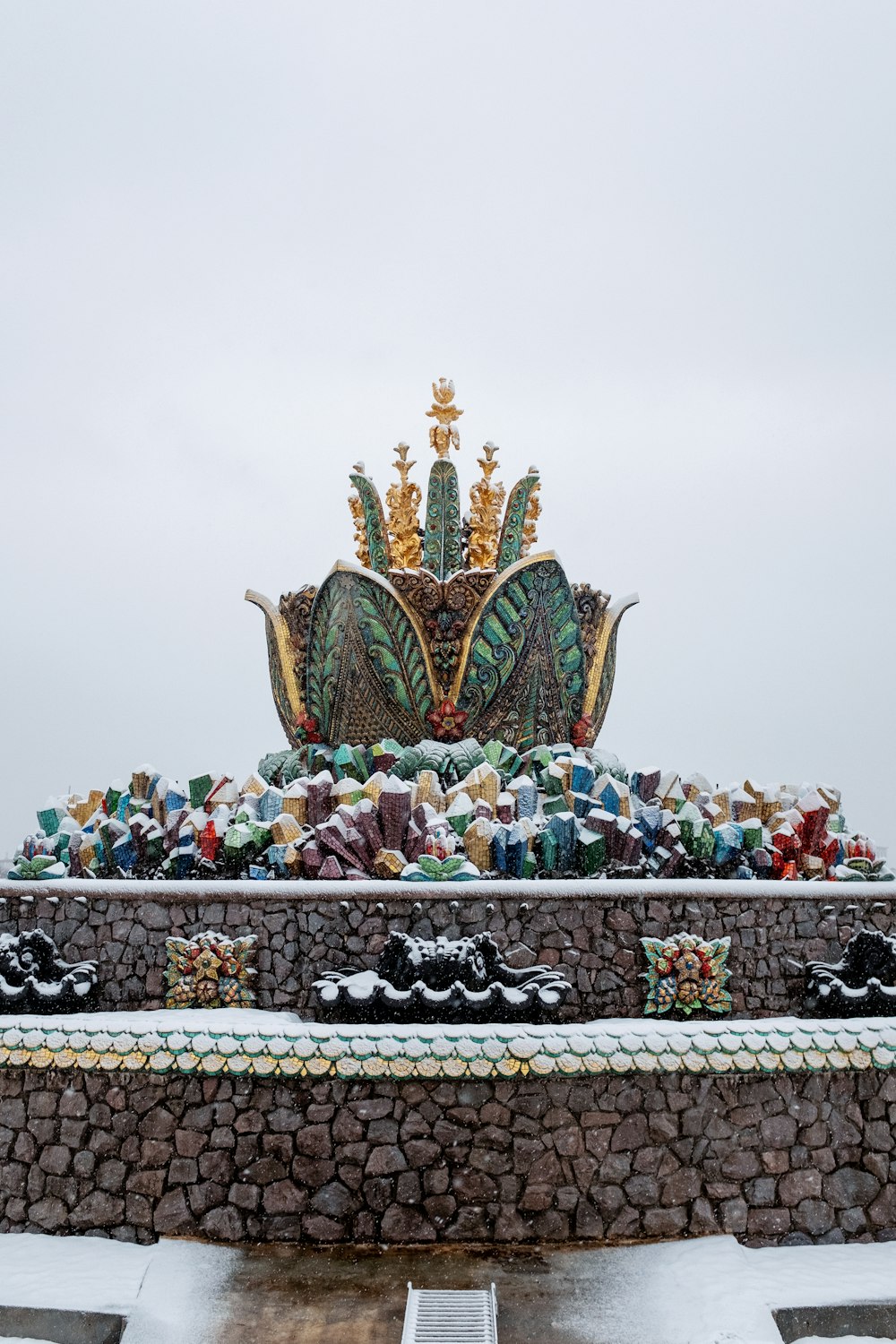 a statue of a crown on top of a stone wall