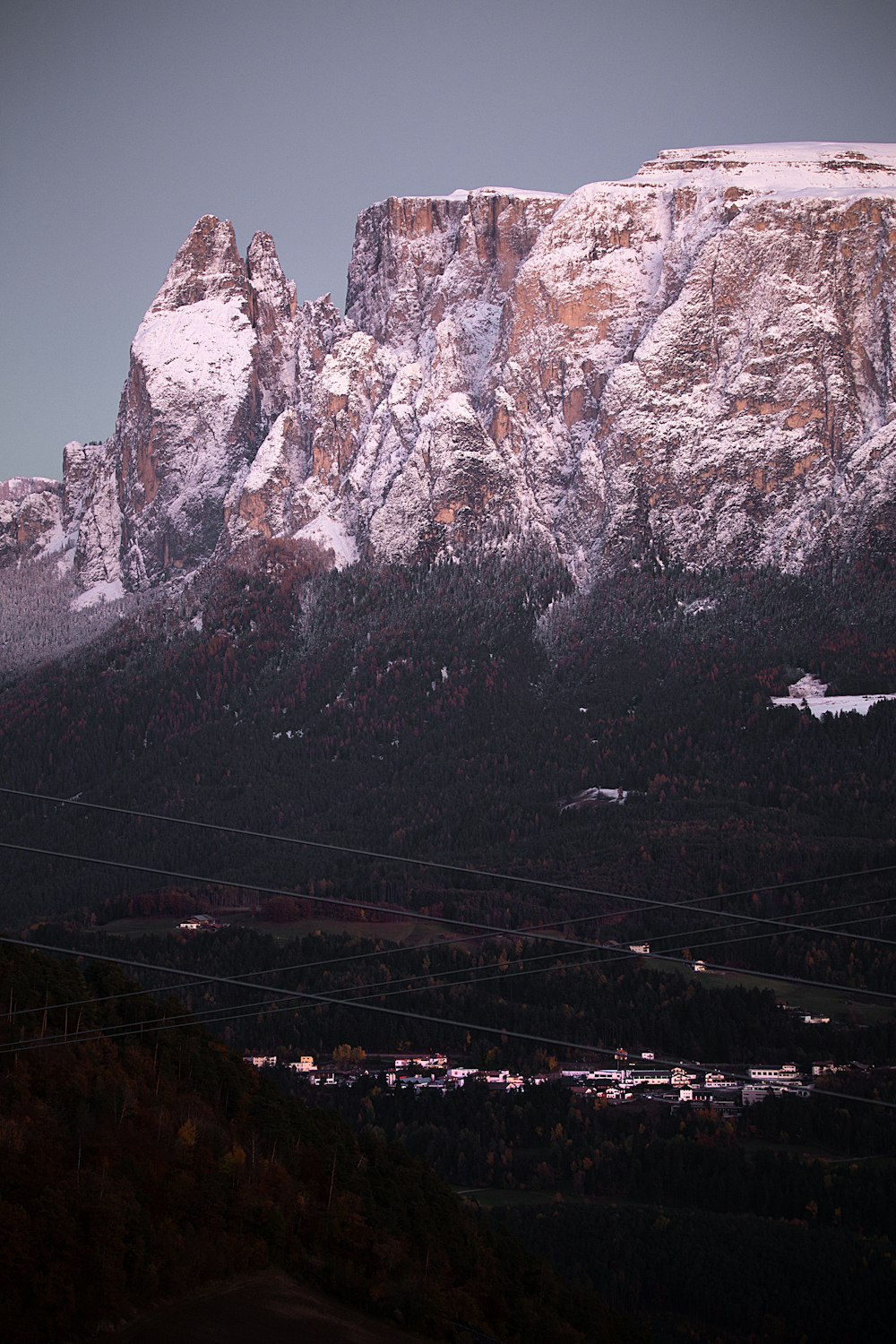 a snow covered mountain with power lines in the foreground