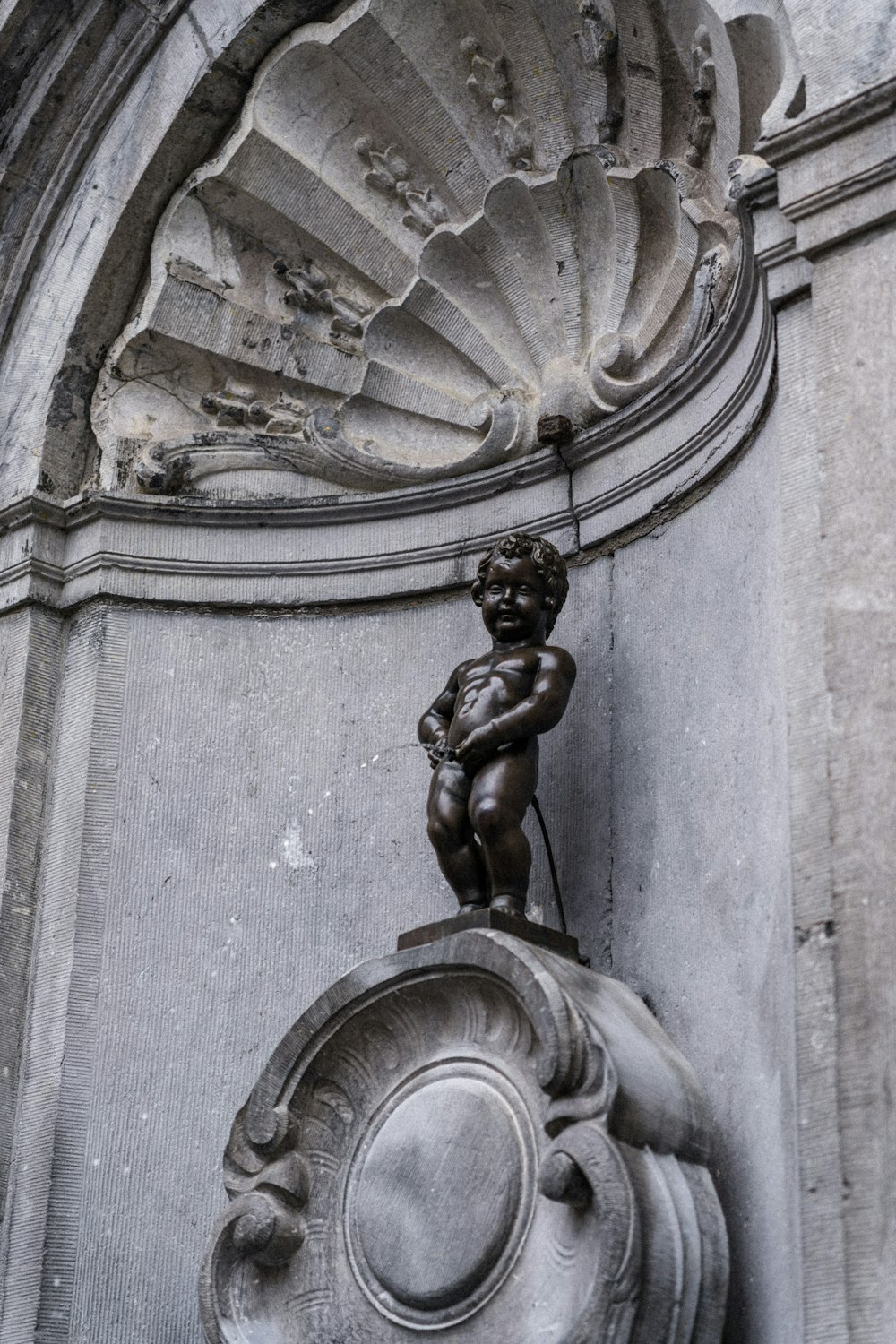 a statue of a boy on top of a fountain