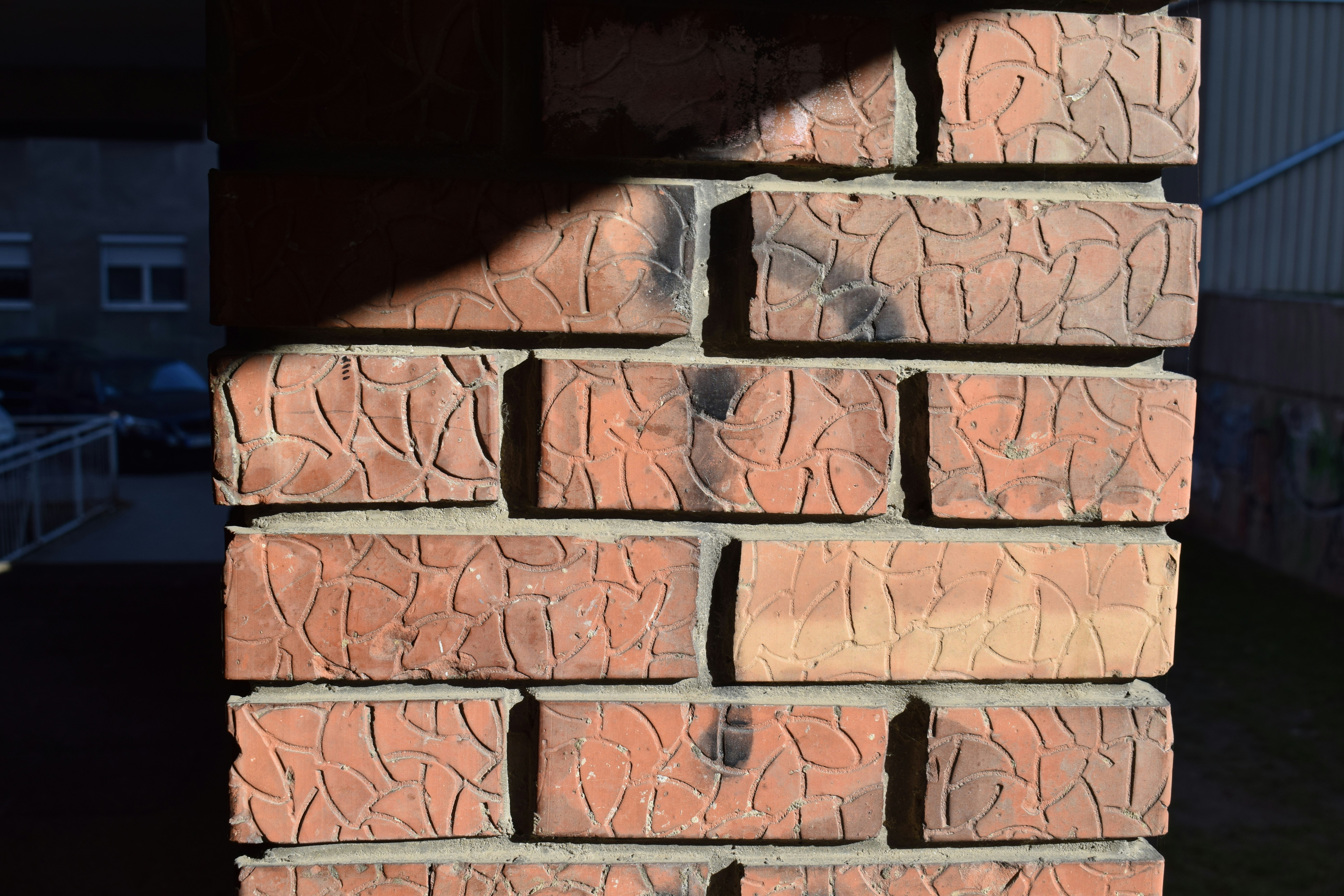 Close-up architectural detail of brick grid bond pattern, precise geometric coursing, dark textured clay brick surface, overcast diffused light