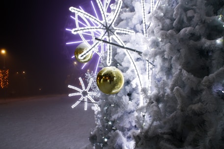 A beautifully decorated Christmas tree surrounded by twinkling lights and snowflakes.