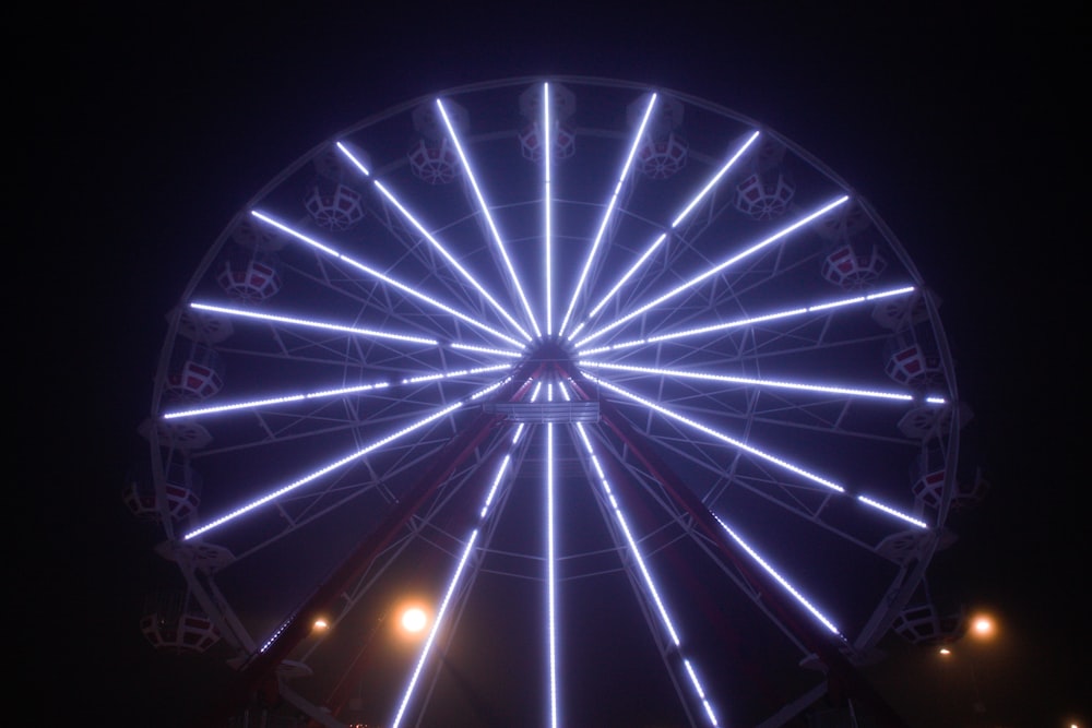 uma roda gigante iluminada no céu noturno
