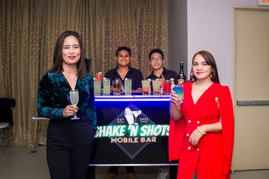 A sleek mobile bar setup at a corporate event with professionals networking and enjoying drinks.