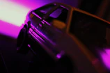 Close-up of a detailed 3D printed automotive accessory glowing under neon blue light.