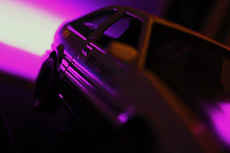 Before and after side-by-side shots of a car’s exterior paint correction under dramatic lighting.