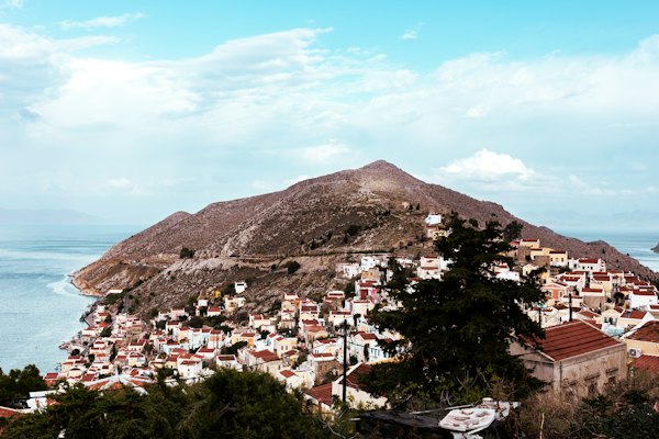 A view of a small town on a hill near the ocean — Symi, Greece