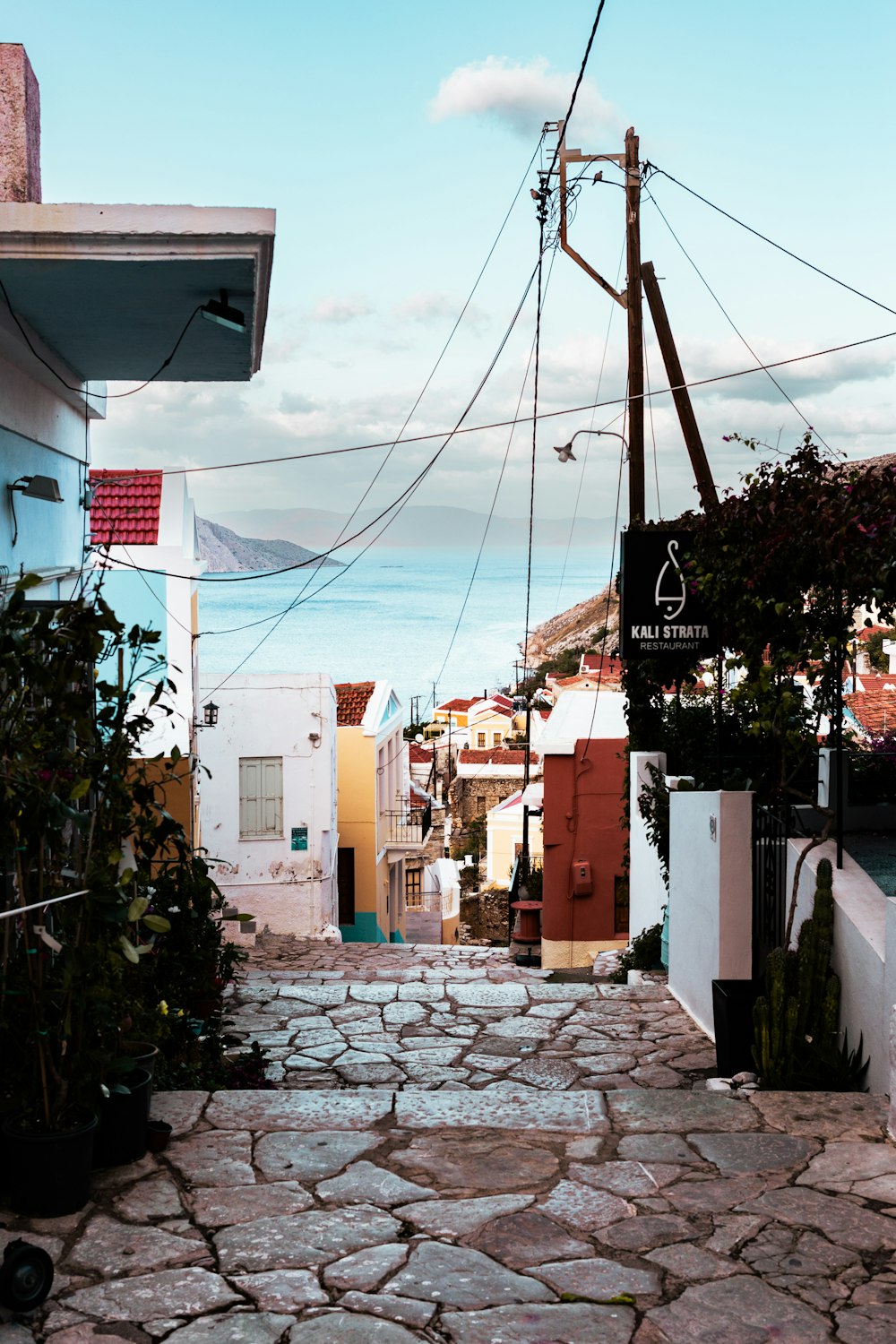 a cobblestone street with a view of the ocean