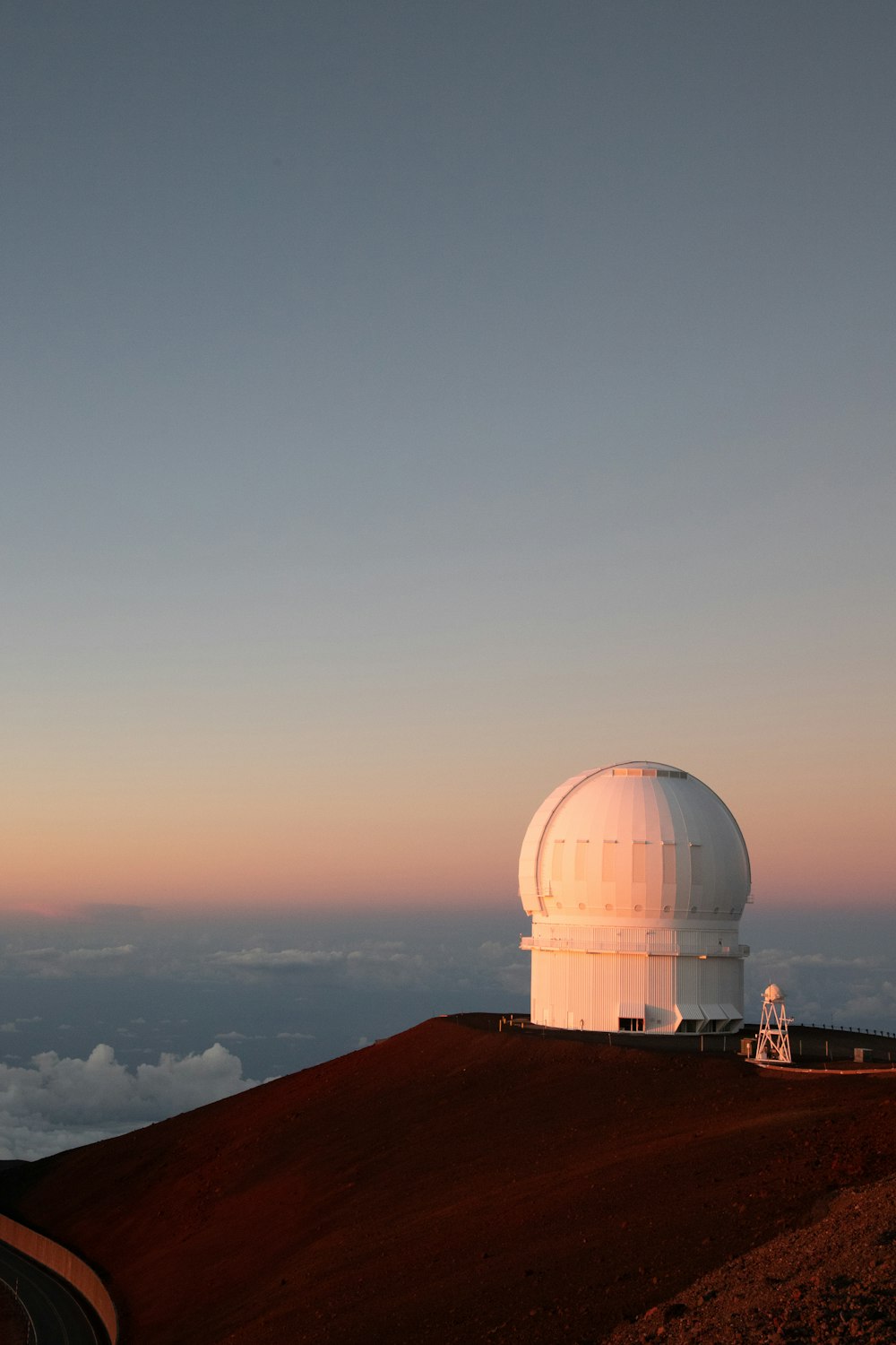 um grande telescópio branco no topo de uma colina