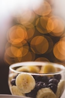 Close-up of crispy banana chips in a rustic bowl with warm yellow lighting.