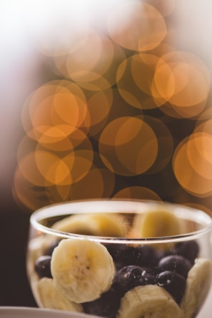 Close-up of crispy banana chips in a rustic bowl with warm yellow lighting.
