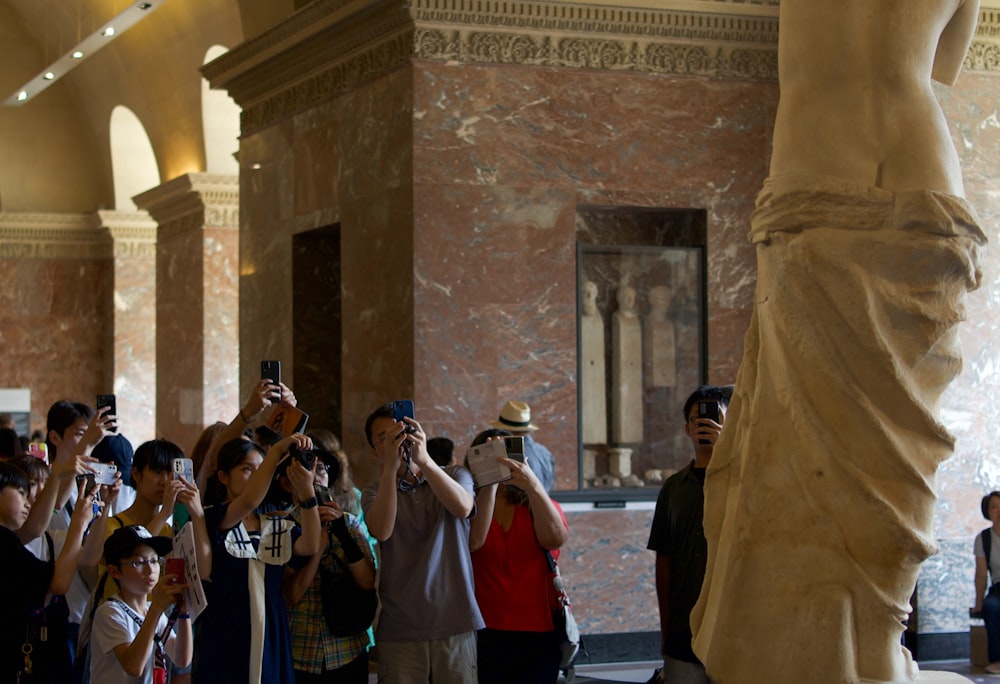 a group of people taking pictures of a statue