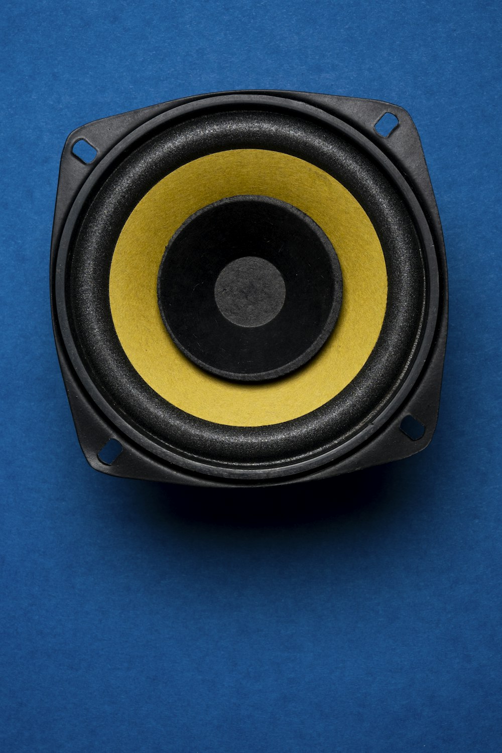 un gros plan d’un haut-parleur sur une surface bleue