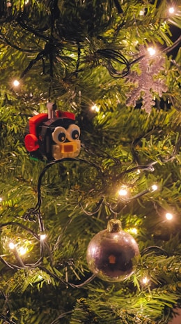 Brightly colored LEGO Christmas ornaments hanging on a decorated tree.